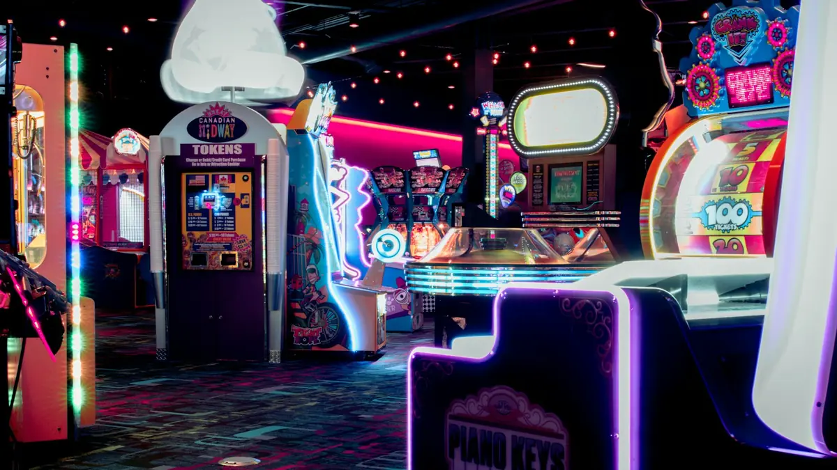 Room full of arcade machines lit by neon lights