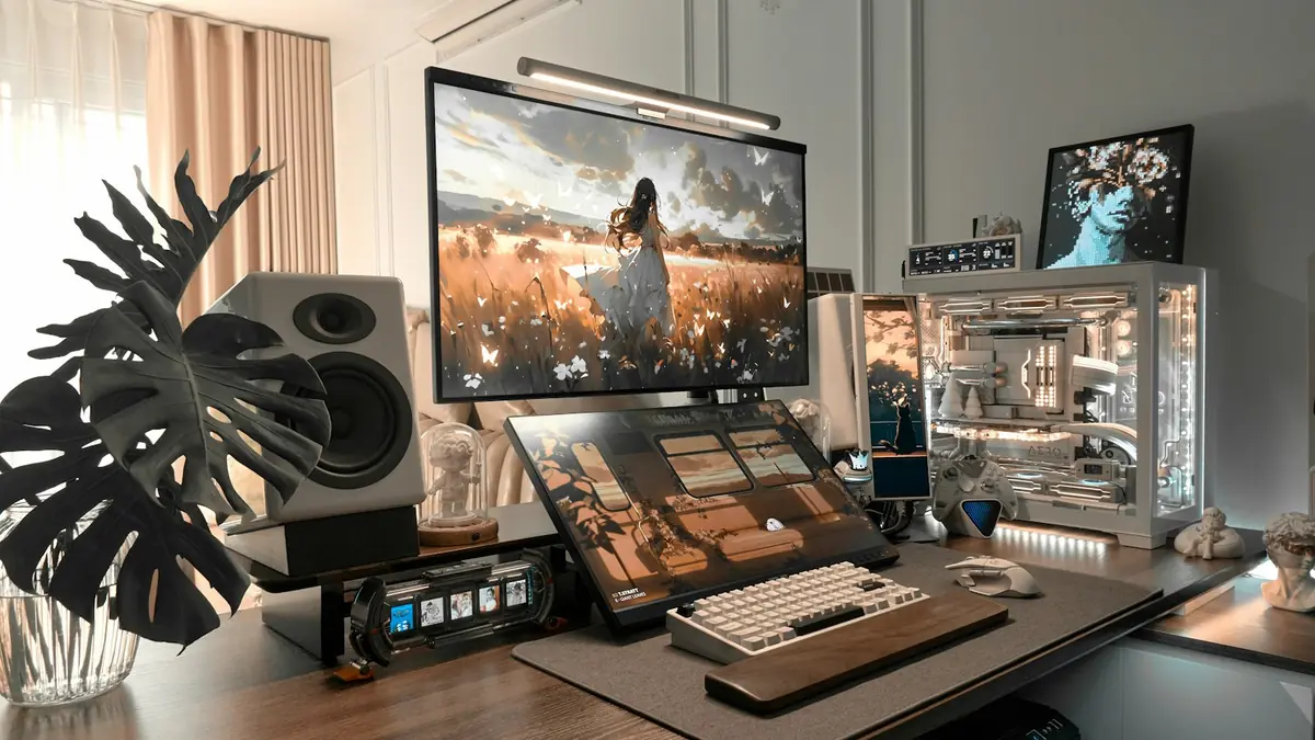 Tidy PC desk with a large monitor, keyboard, speakers and a white PC case with glass panels